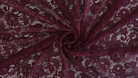 Material burgundy răsucit în spirală cu motive florale vizibile