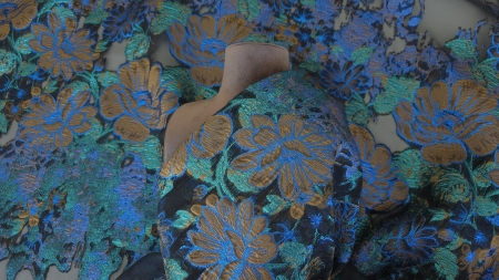 Material drapat pe manechin cu flori arămii și contururi metalice albastru electric repartizate uniform pe bust