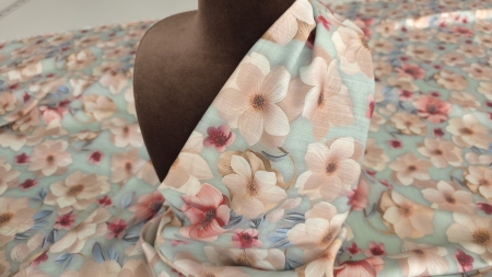 Material floral sidefat drasat pe manechin maro cu flori mari roz pudrat și accente coral