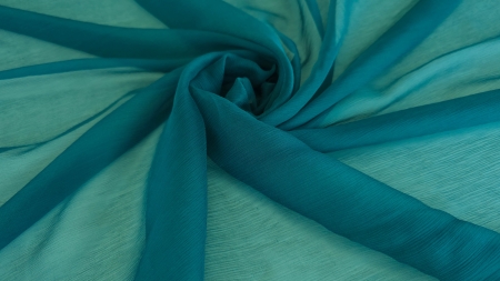 Material teal creponat aranjat în spirală cu centrul mai saturat