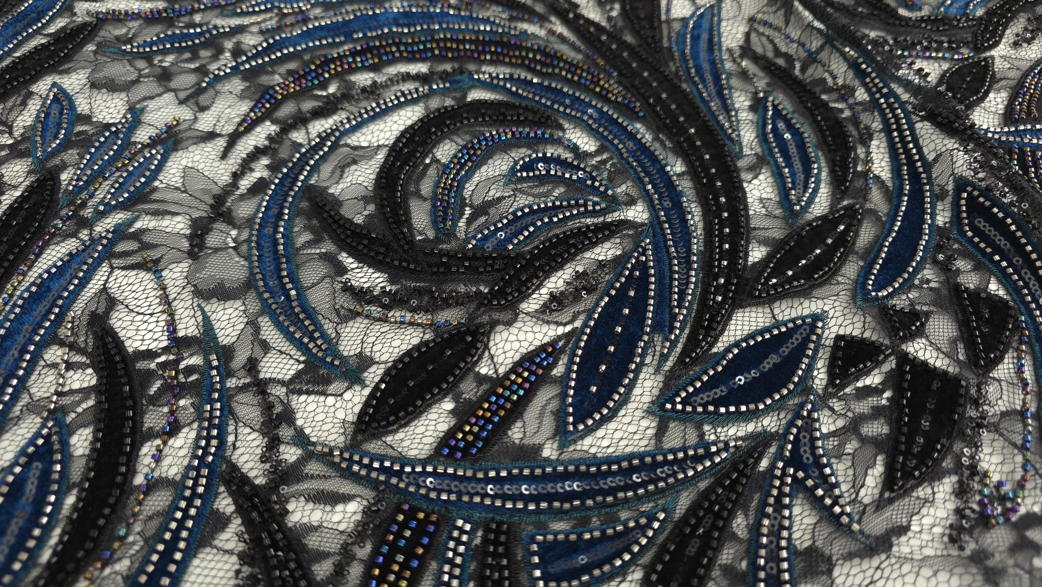 Materialul în falduri naturale cu reflexii diferite pe margele și paiete