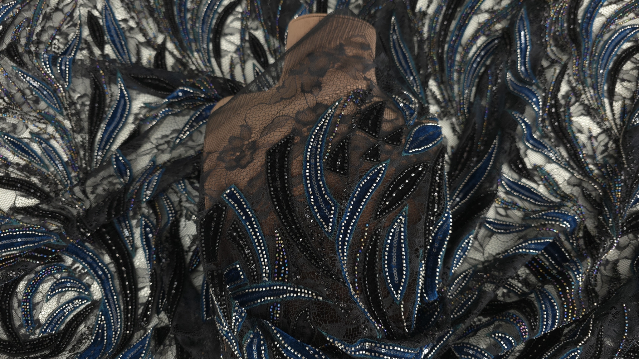 Materialul pe bust cu frunze turcoaz închis și negre din catifea, margele multicolore și argintii