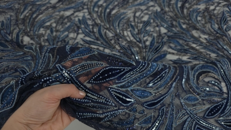 Materialul ținut în mână cu transparența tulle ului bleumarin vizibilă