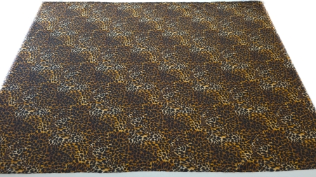 Metraj complet de material animal print desfășurat pe masă pe toată lățimea