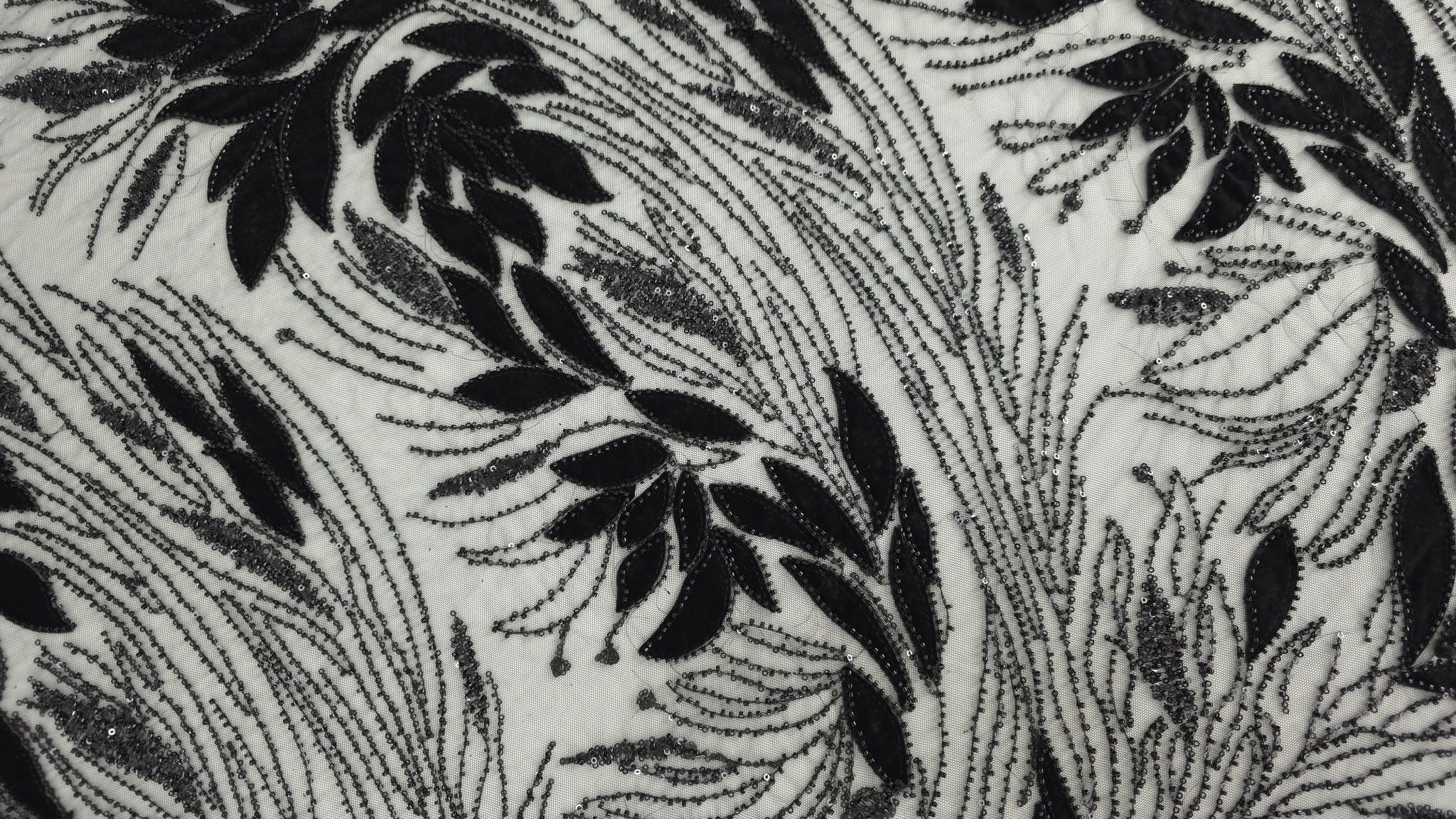 Micropaiete cusute de a lungul ramurilor din catifea neagră pe fond transparent