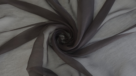 Muselină de mătase naturală maron închis creponată aranjată în spirală pe fundal alb