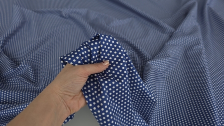 Poplin albastru elastic cu buline mici albe strâns în mână cu faldul bogat în pliuri