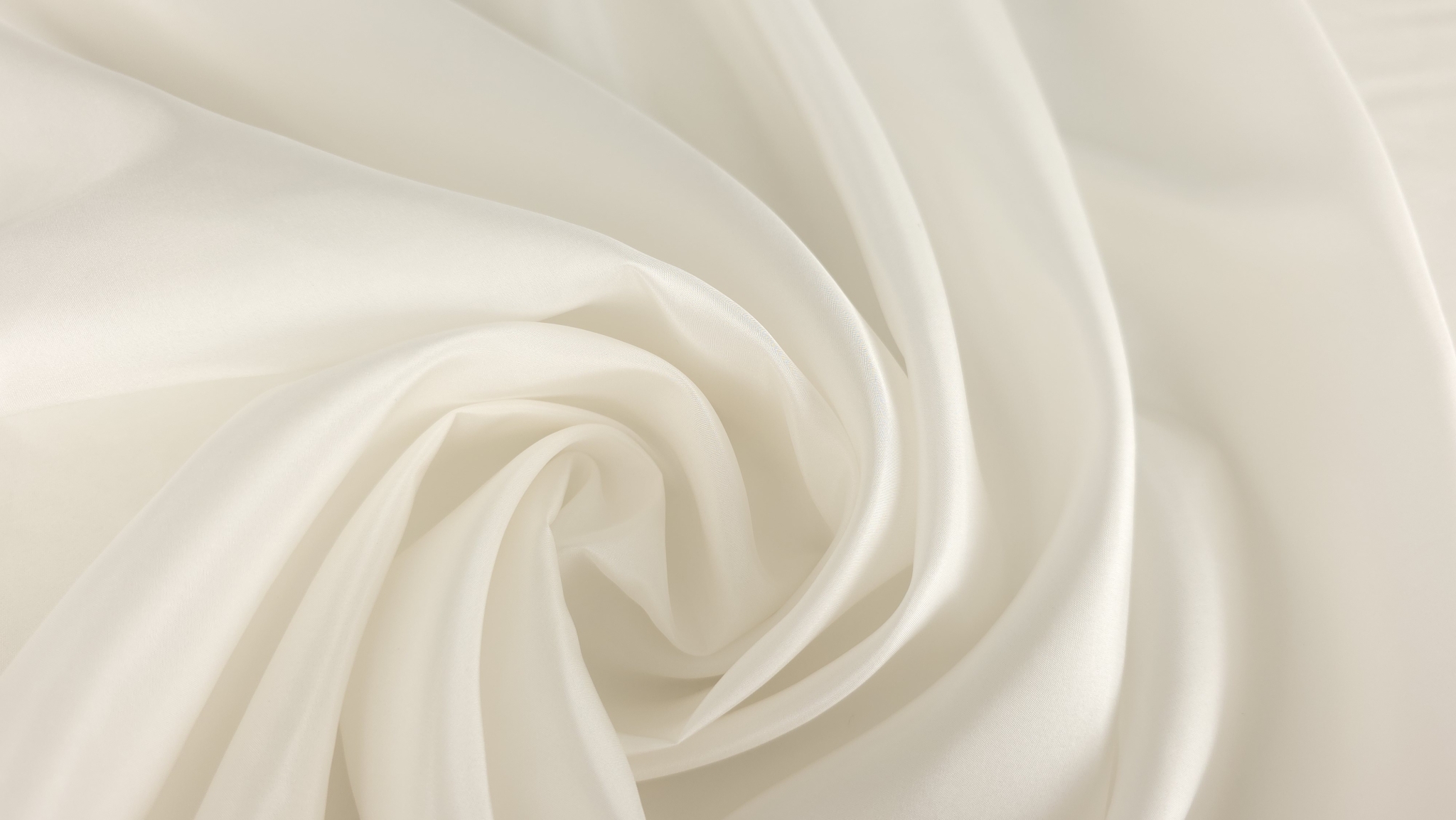 Spirală de falduri din căptușeală ivoire de mătase arătând căderea fluidă a materialului