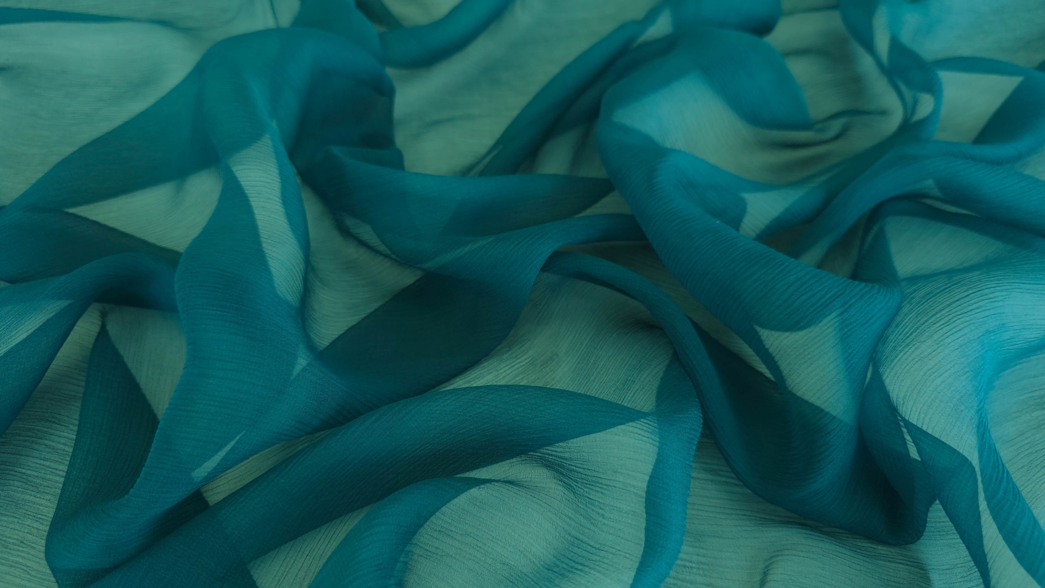 Suprafață creponată albastru verde petrol cu falduri multiple și umbre adânci