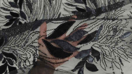 Suprafața materialului brodat cu alternare de elemente mate și lucioase