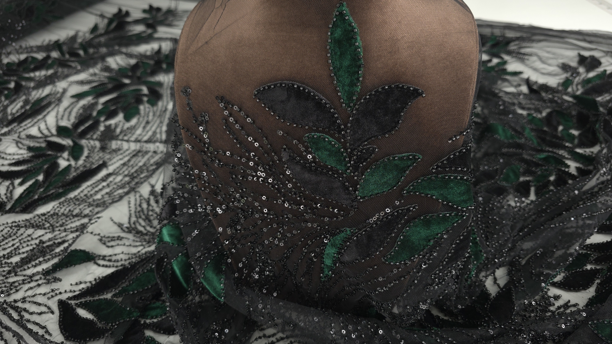 Tulle brodat cu micropaiete și catifea verde pădure prezentat pe bust