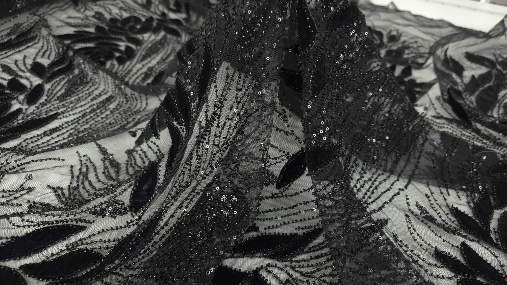 Tulle negru brodat cu catifea și margele la metru, vedere a căderii materialului
