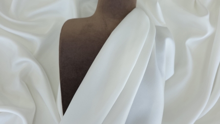 Twill ivoire de mătase naturală aranjat pe bust maro de prezentare, falduri diagonale