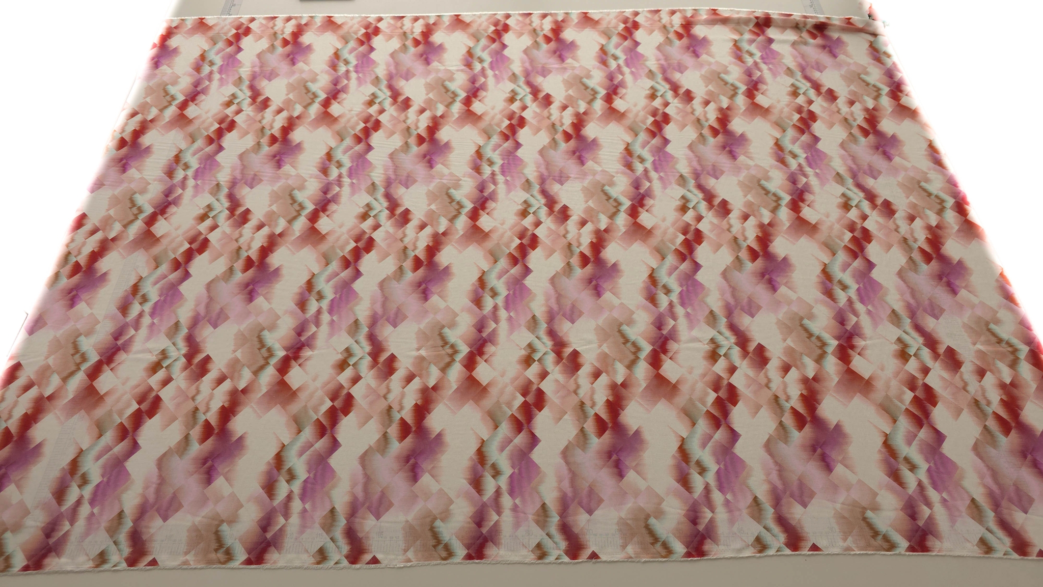 Vascoza imprimata digital geometric multicolor în tonuri de roz, roșu și mov, vedere generală a materialului desfășurat