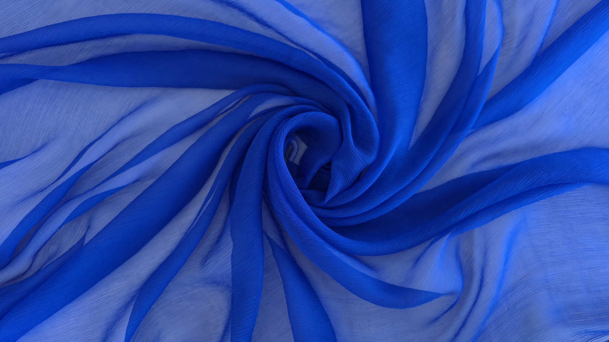 Țesătură fină albastră aranjată în spirală pe fundal deschis