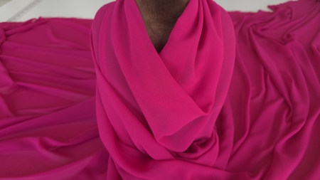 Voal georgette magenta drapat pe bustul manechinului cu falduri adunate la baza gâtului