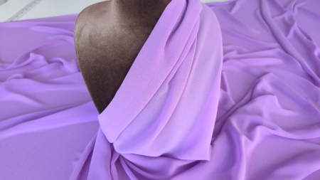 Voal georgette mov lila drapat pe bustul manechinului cu pliuri adunate la baza gâtului