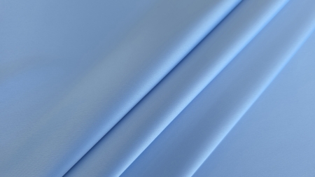 Falduri diagonale paralele material albastru pastel suprafață netedă cu reflexii line de lumină
