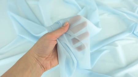 voal semitransparent albastru delicat strans in mana detaliu transparenta
