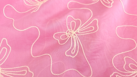 Detaliu broderie fundita ivory pe voal roz, fire rasucite tip lant in prim plan, textura fina vizibila