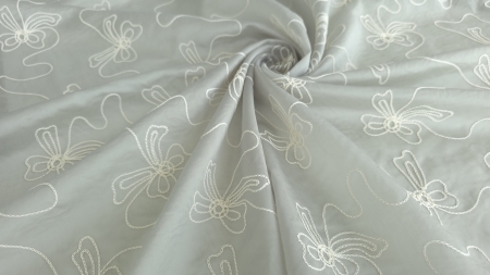 Fond gri perlat rasucit in spirala, broderie ivory in contur simplu vizibila pe creste, falduri ample cu volum natural