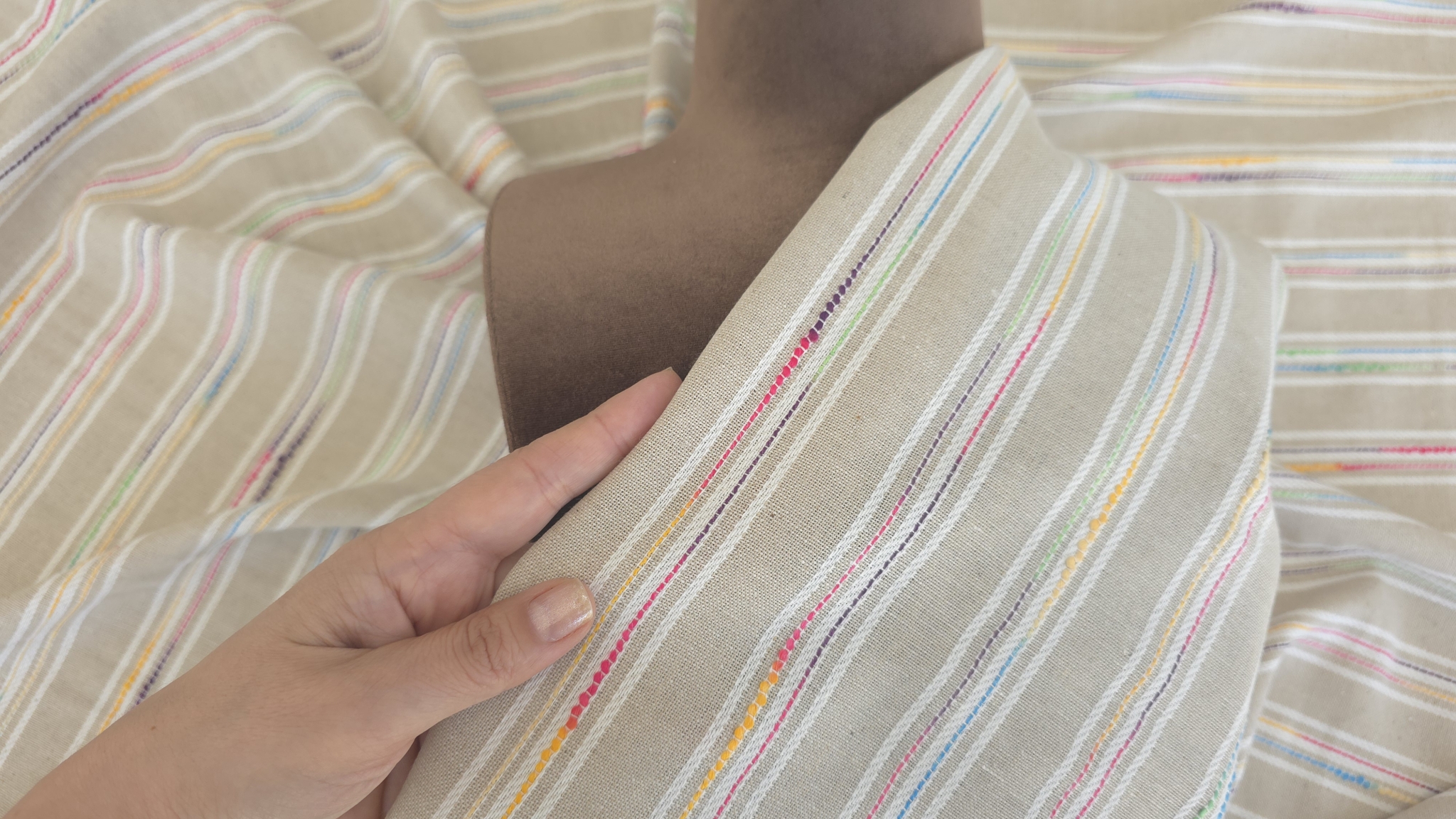 Material cu in dungi ivory multicolor desfășurat în diagonală pe fond alb