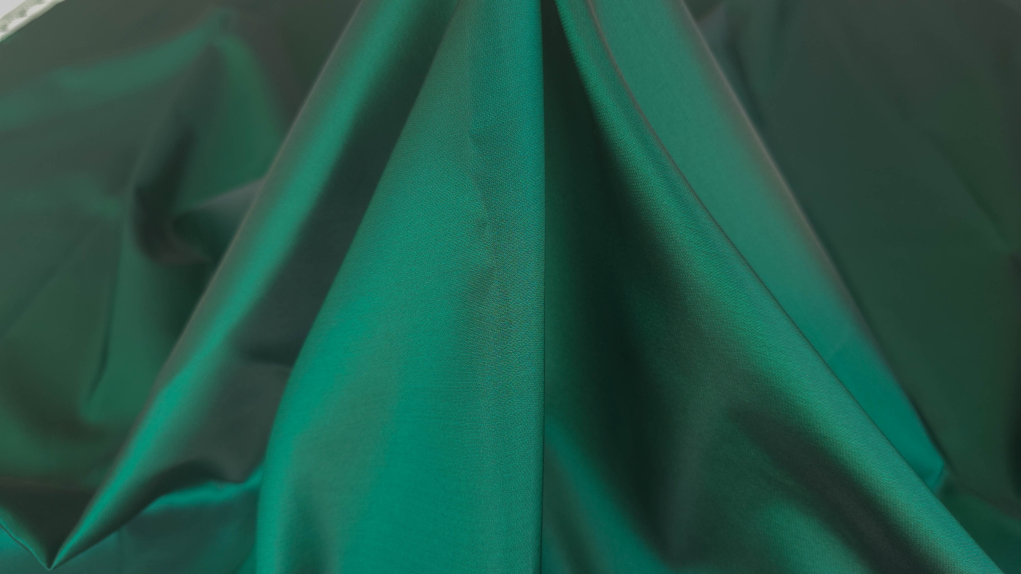 Metraj de mikado verde intens cu mătase naturală fotografiat în falduri largi, față perlată vizibilă