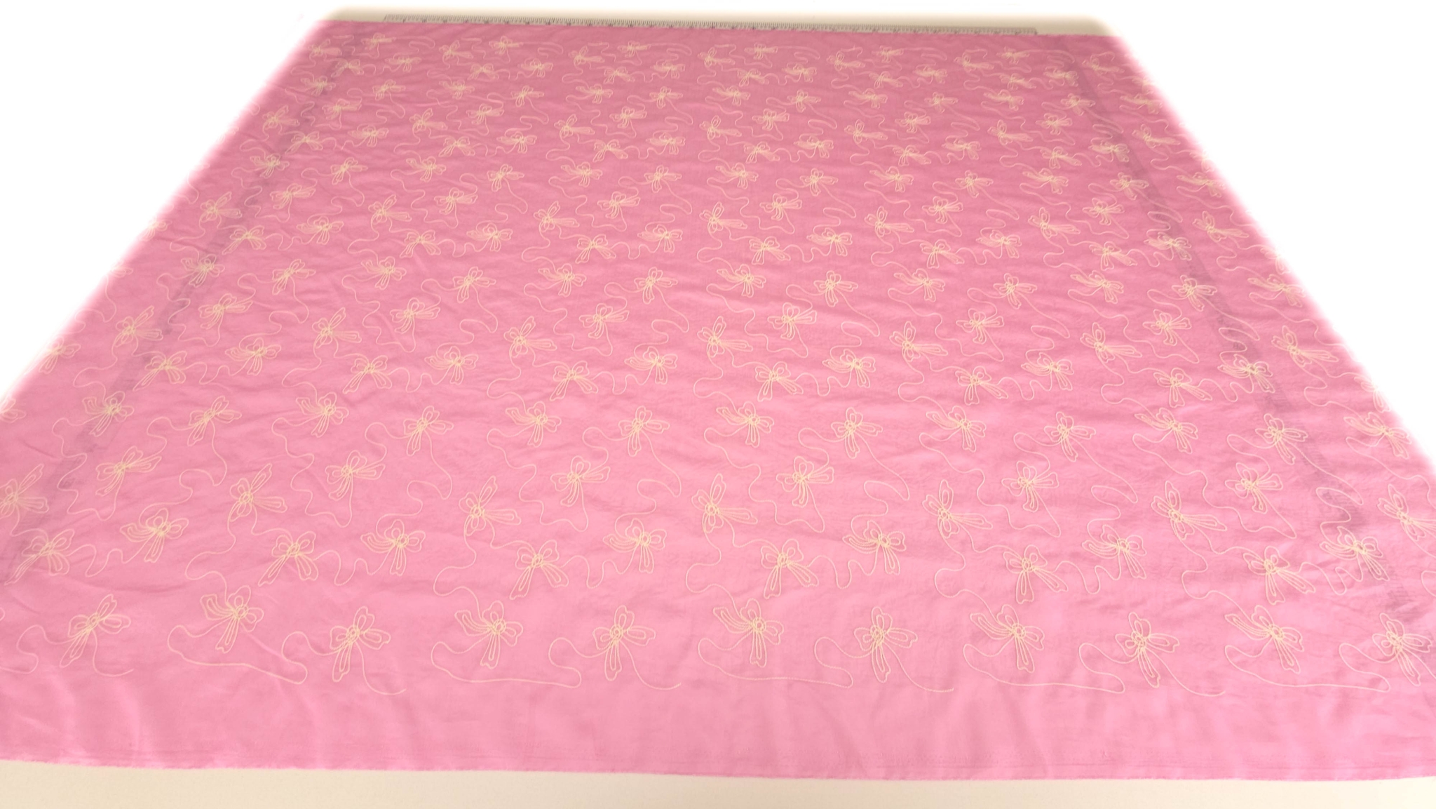 Voal natural sweet pink cu broderie de vara, vedere generala pe masa, fond roz cu motive fundita ivory distribuite uniform