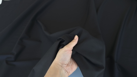 material negru strâns în mână falduri moi structură flexibilă