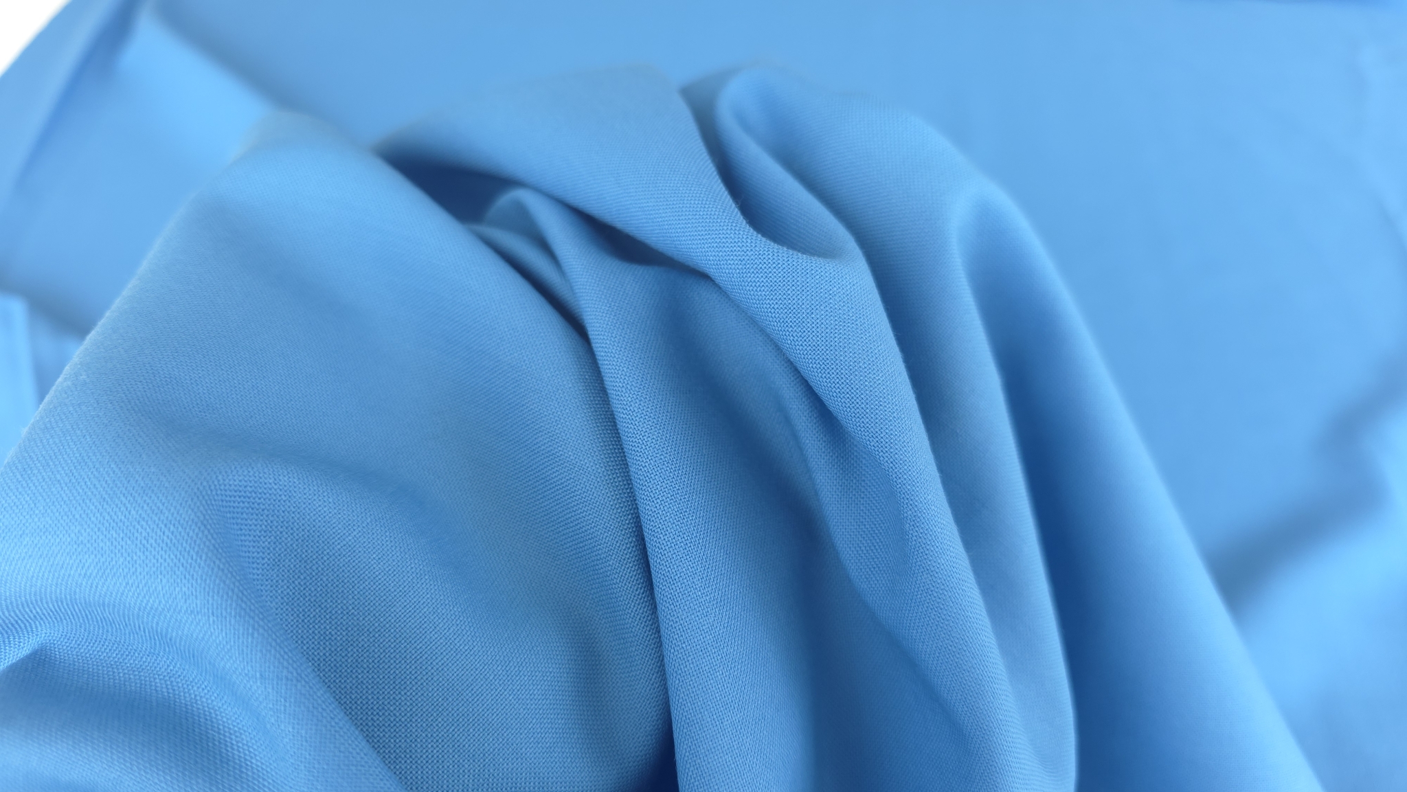 Falduri de material bleu așezate pe mână