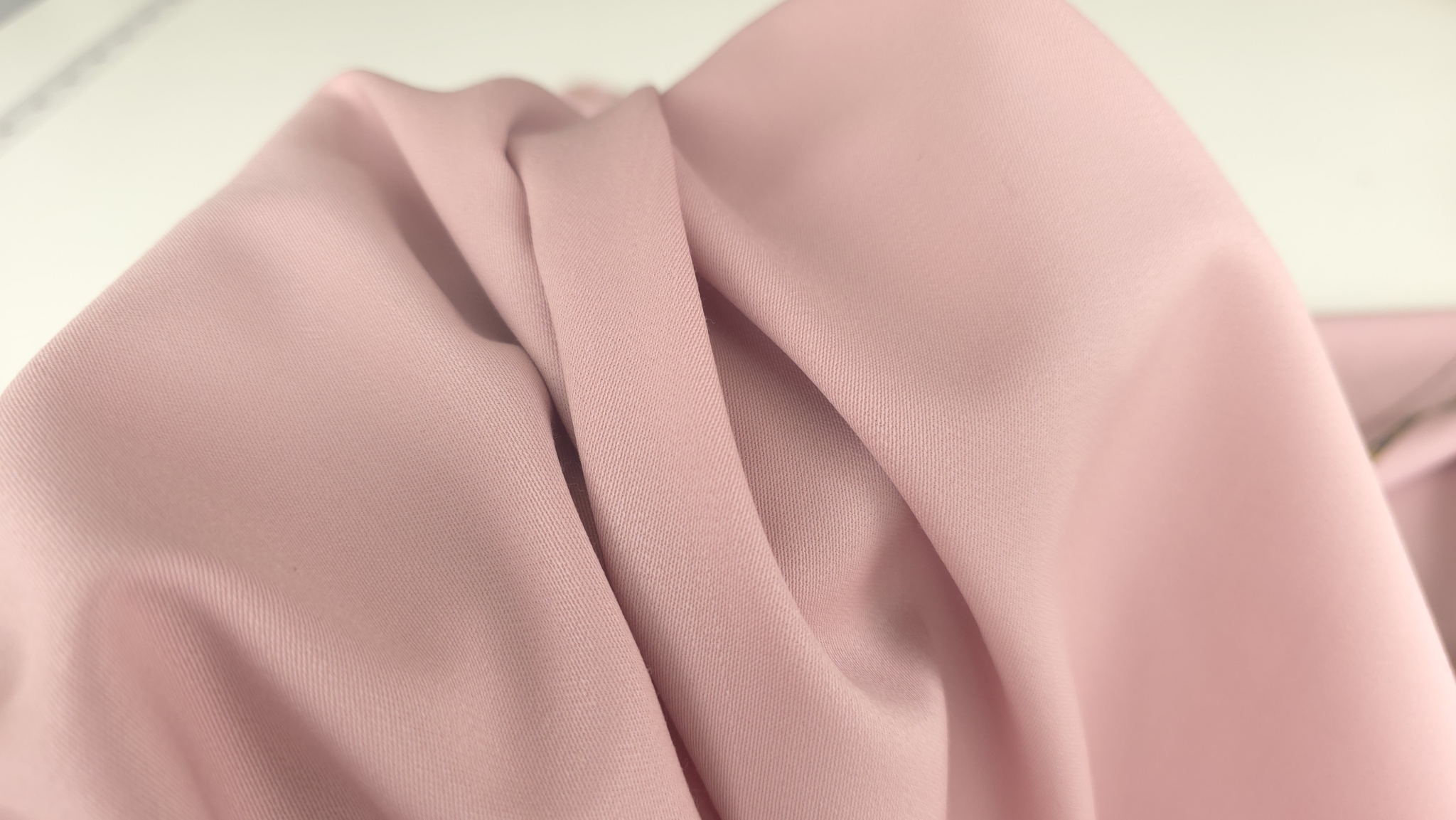 Falduri powder pink adunate in valuri suple in prim plan