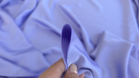 Marginea unei țesături lila netede cu tăietură fină