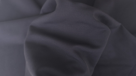 Material bistretch pentru costume bleumarin pus pe mana