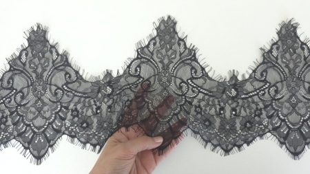 dantela decorativa neagra tinuta in mana cu franjuri fini pe margine