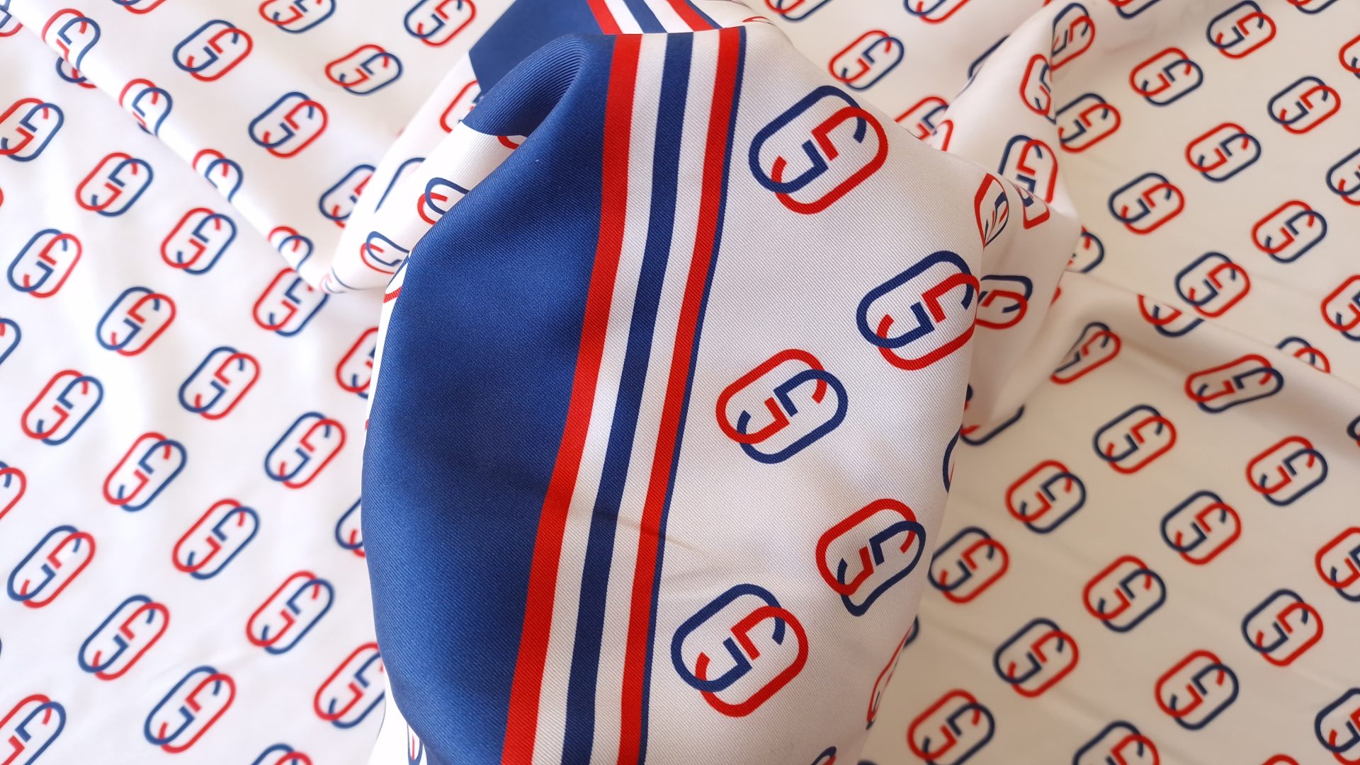 detaliu panou cu bordură bleumarin și dungi roșii pe fond crem