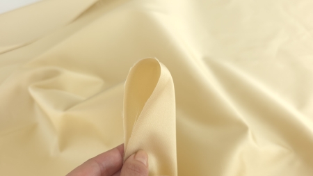 material nude auriu pentru tinute de gala, margine prinsa intre degete