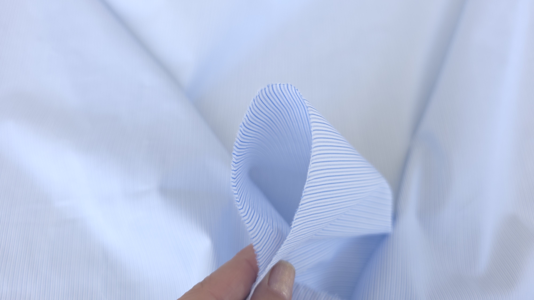 material fin prins între degete cu textură netedă