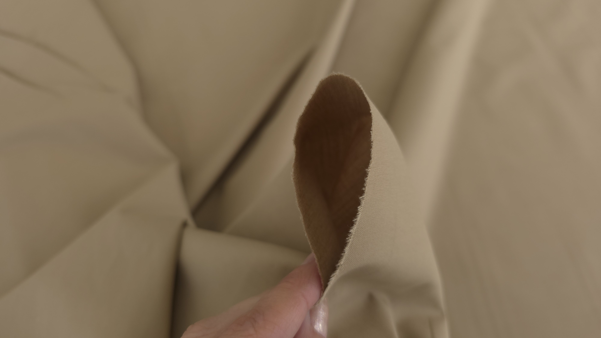 poplin nude inchis tinut intre degete cu revers deschis