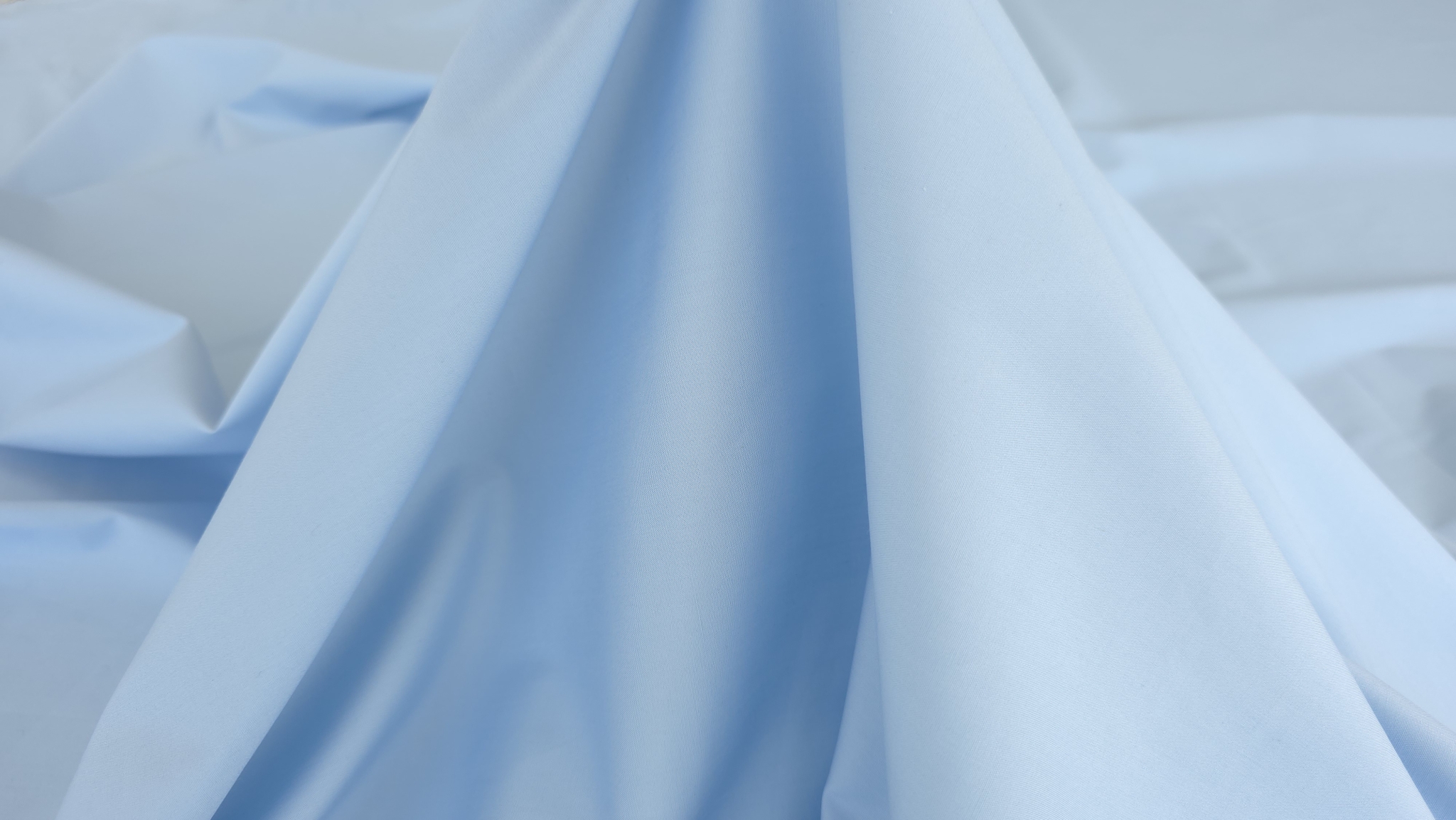 tesatura bleu deschis cu cadere stabila si fluida in pliuri
