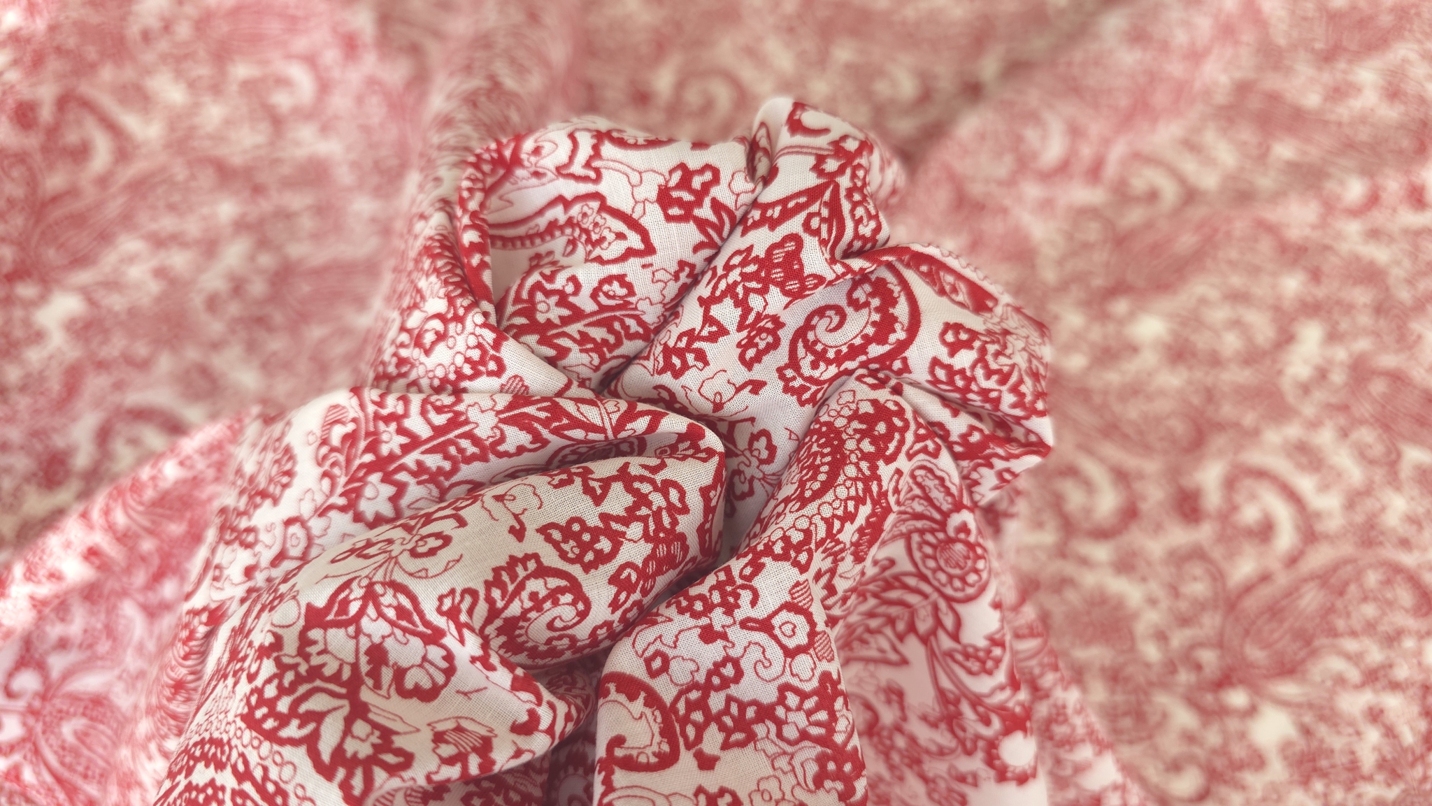 tesatura fluida stransa in nod central cu paisley rosu si crem