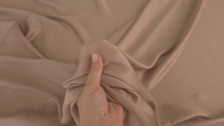 tesatura satinata mocha mousse pentru captuseala prinsa in mana