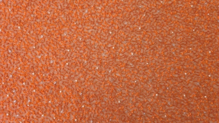 Broderie orange delicată lucrată manual, material desfășurat pe suprafață plană