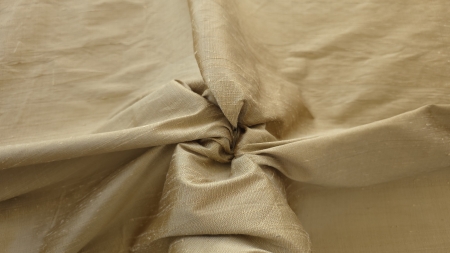 Material auriu strans in mana, cu relief accentuat al firelor pe suprafata