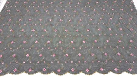 Tulle negru brodat cu flori întins pe masă, cu desen floral multicolor pe toată suprafața