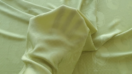Bucată subțire ținută în palmă, cu cute moi și suprafață lucioasă