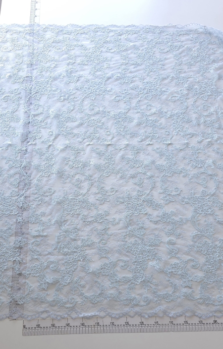 Dantela tip chantilly rebrode sky blue, întinsă pe masă și măsurată cu rigla
