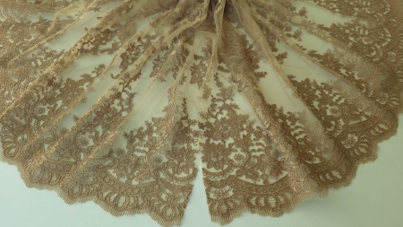 Material dantelat nude bronz desfășurat în evantai, cu bordura spre exterior