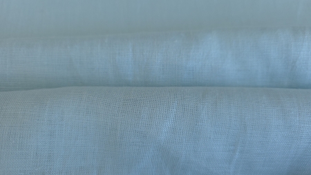 Falduri ample de material verde pastel, cu suprafață mată