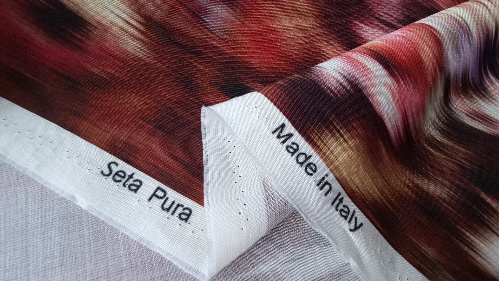 Margine cu inscripțiile Seta Pura și Made in Italy, lângă model cu buchete