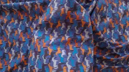 Suprafață colorată ținută în palmă, cu cute moi și desen mărunt